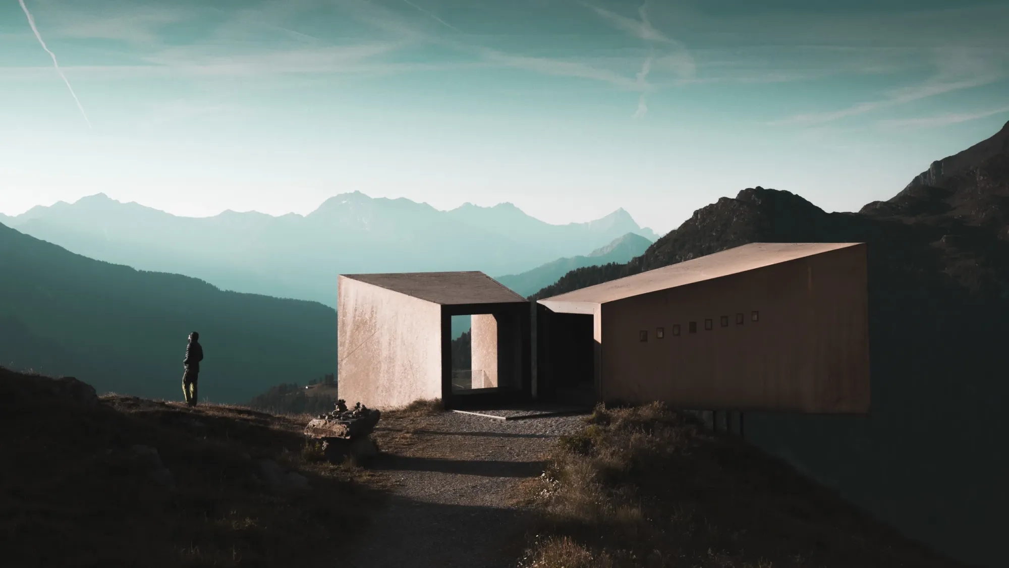 Moderne Architektur-Pavillons in den Bergen, eine Person blickt auf das Alpenpanorama