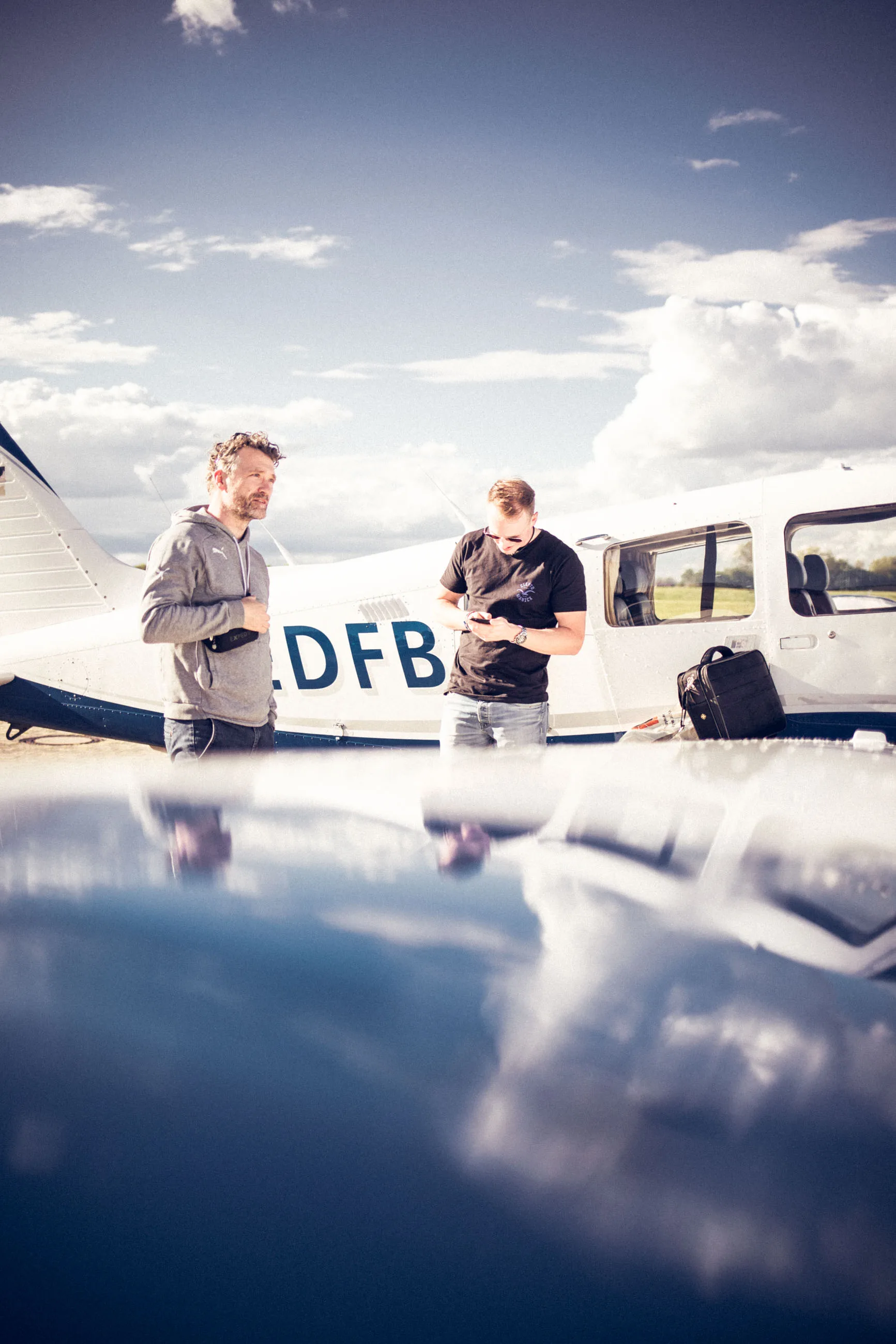 Zwei Piloten an einem Kleinflugzeug auf dem Flugplatz