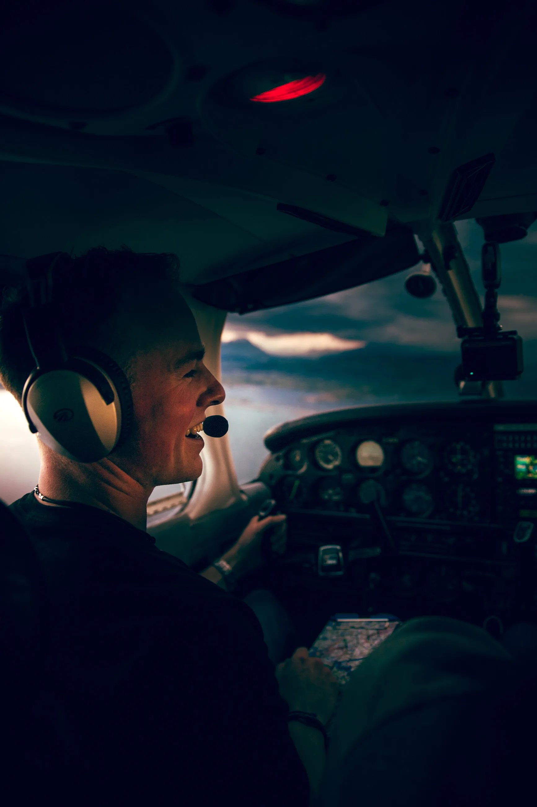 Pilot im Cockpit eines Kleinflugzeugs in der Dämmerung